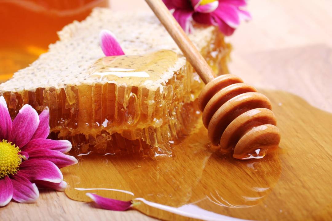 عسل با موم و قاشق چوبی عسل 